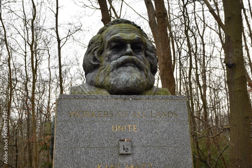Photos Sculpture of Karl Marx at Highgate Cemetery, London, symbolizing historical discussions on socialism and workers' rights amidst serene natural surroundings