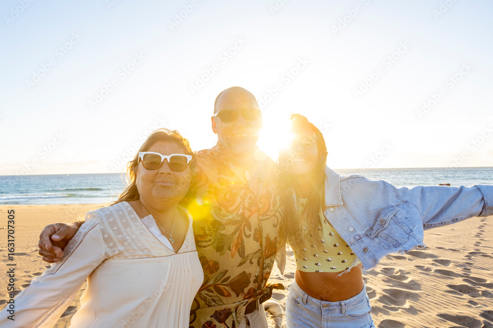 Fototapeta premium Happy tourists embracing on the beach at sunset after spiritual retreat