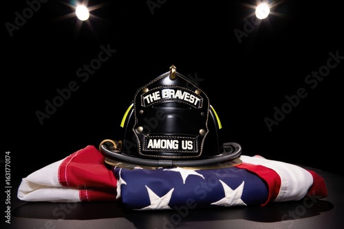 A poignant image of a firefighter's helmet resting on an American flag, honoring 9/11 victims.