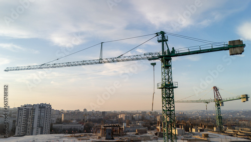 Tower crane at construction site with city skyline in background