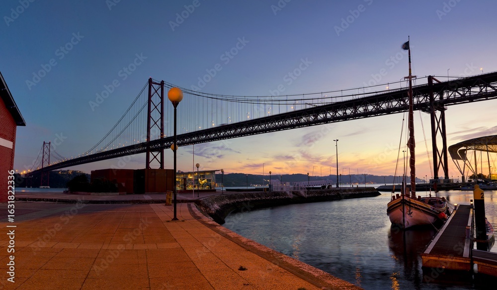 Fototapeta premium The 25 de Abril Bridge panoramic sunset view in Lisbon, Portugal