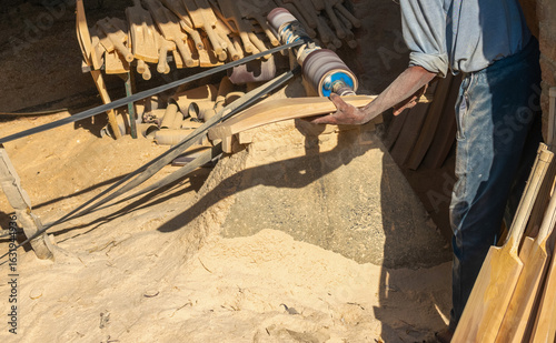 A worker carves an unfinished cricket bat at sports manufacturing factory in Meerut, a largest sports manufacturer, producer of sports gear and equipment.