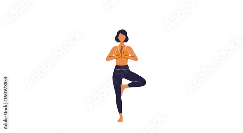 A woman with short dark hair practices the Tree Pose yoga asana, balancing on one leg with hands in prayer.