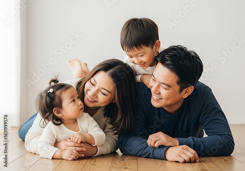 Joyful asian family of four sharing a loving moment together on the floor