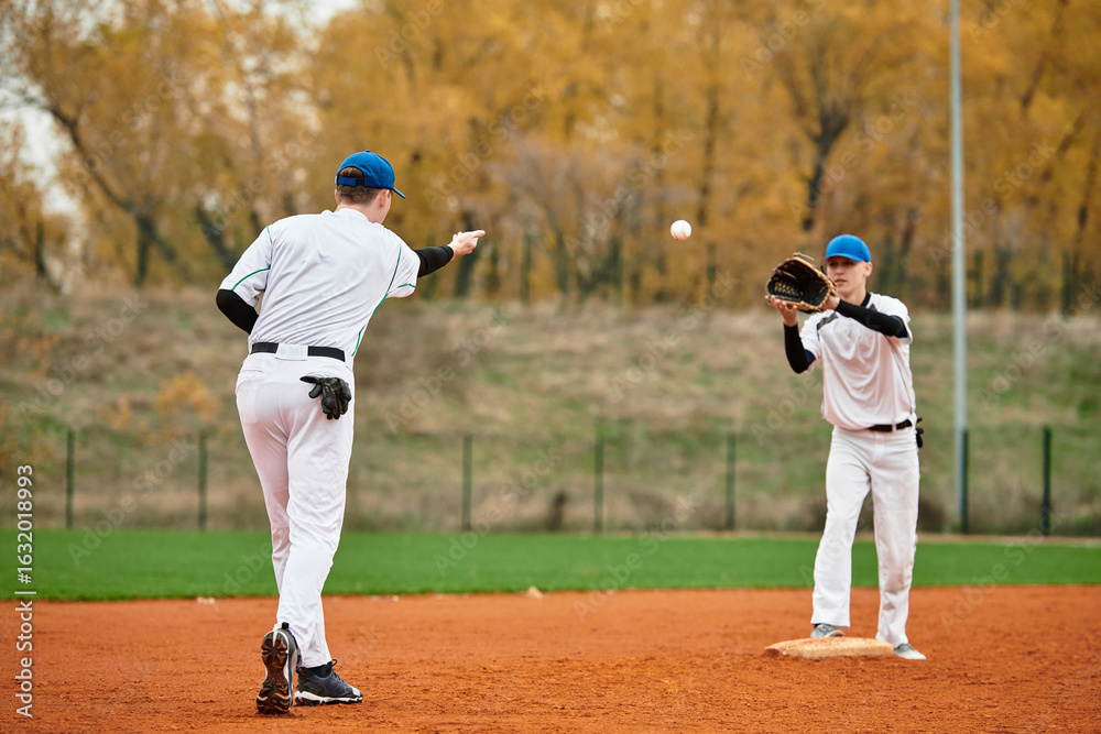Two teenage boys engage in an exciting baseball practice on a sunny afternoon field Two teenage boys engage in an exciting baseball practice on a sunny afternoon field