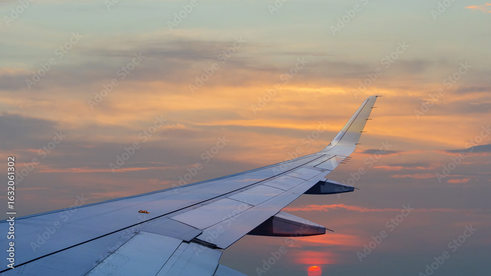 Obraz premium View from inside airplane flying above over sky in sunset light.