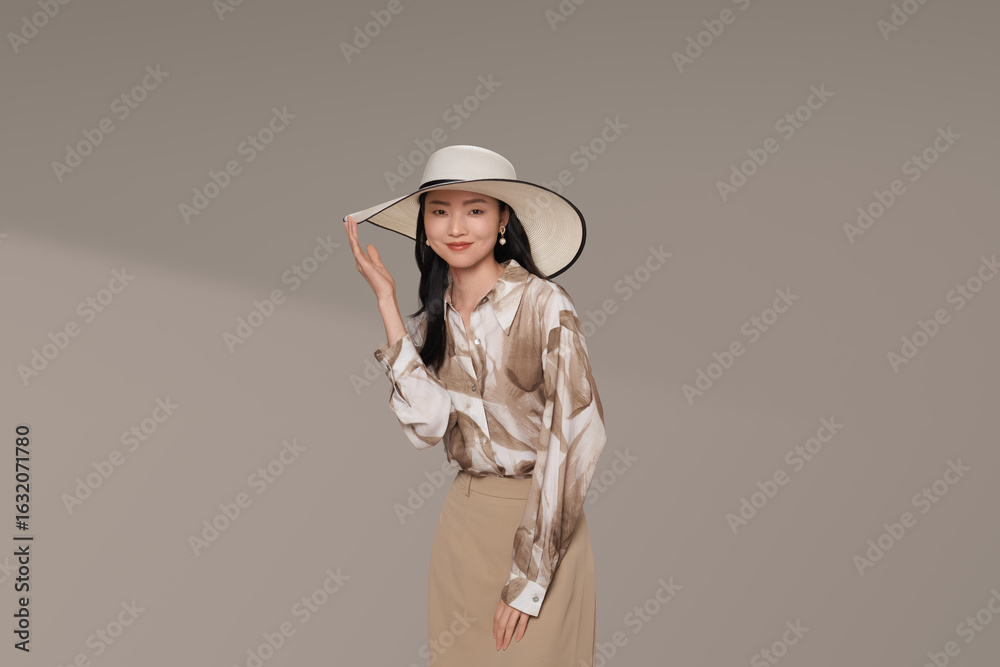 Woman in stylish outfit with a hat and playful pose. Woman in stylish outfit with a hat and playful pose.