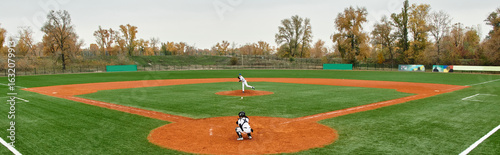 Canvas Print Teenage boys engage in spirited baseball game on a lush field in autumn