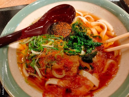 Spicy udon soup with hearty toppings and rich red broth.