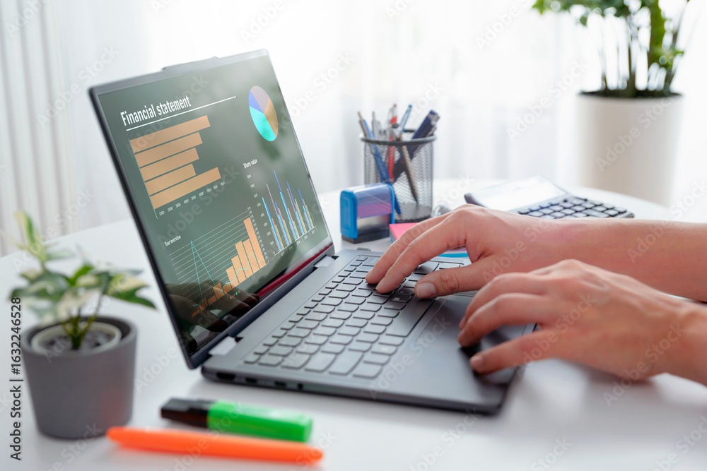 Fototapeta premium Man using 2 in 1 laptop to financial data analysis