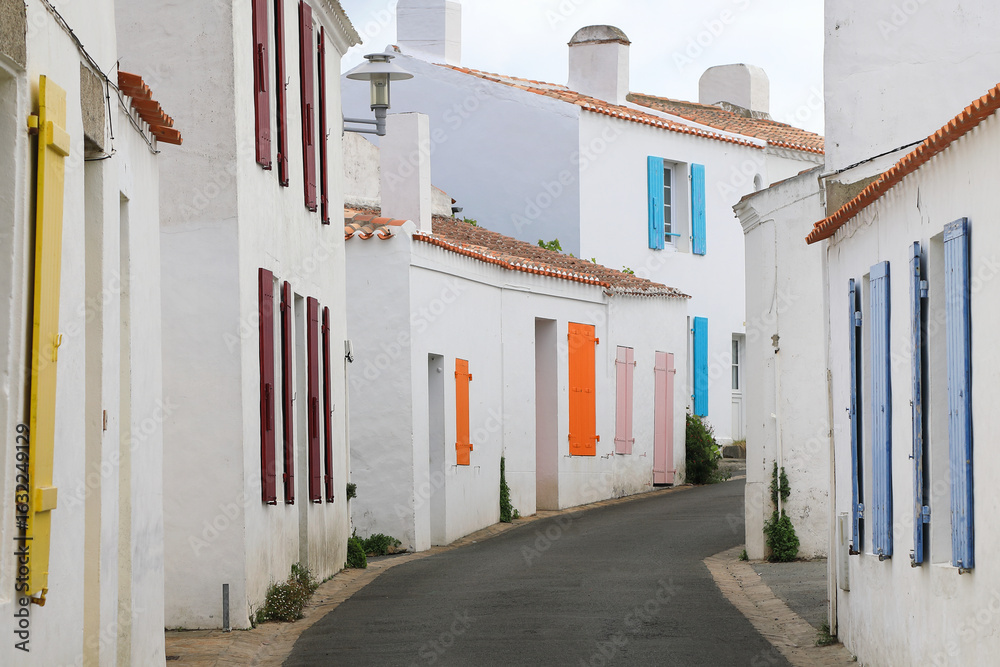 Fototapeta premium Typical street of french atlantic islands with white houses and colorful shutters