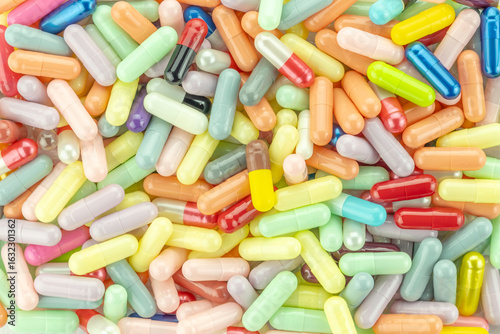 Colorful medicine pills and capsules background. A vibrant texture or pattern from a top-down view for the pharmaceutical industry.