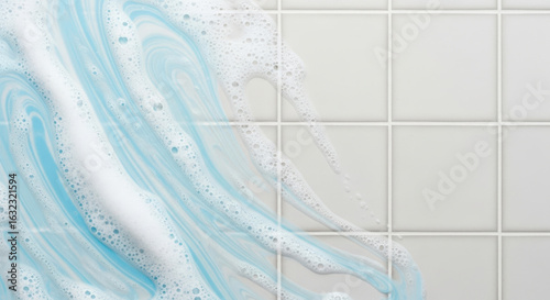 Blue and white soap foam swirls on clean tile wall, fresh and sparkling bathroom concept