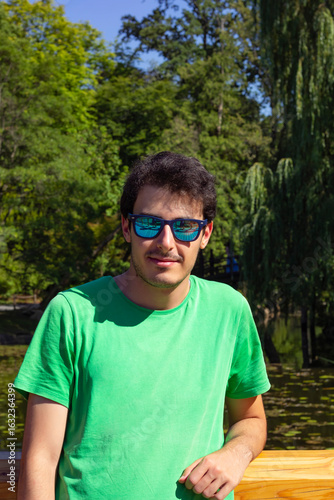 portrait of young handsome man in sunglasses looking at camera