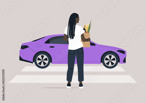 A person stands at a pedestrian crossing, holding a grocery bag filled with fresh produce, while cars wait ahead, adding to the urban buzz in the bright daylight