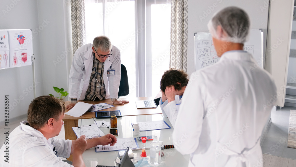Obraz premium A medical error. The head physician of the clinic chastises his subordinate for harming the patient. A group of doctors gathered around a table