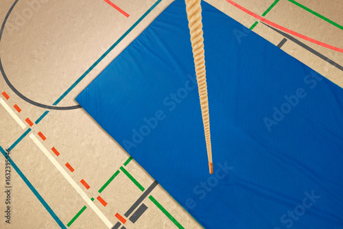 Sporthalle mit Kletterseil und einer Bodenmatte