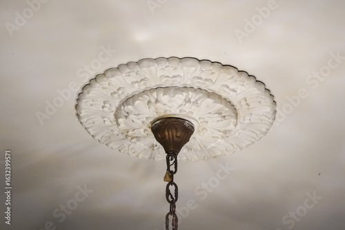 Ornate White Ceiling Medallion with Antique Brass Light Fixture.