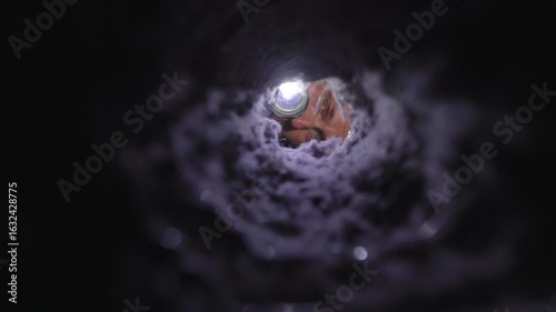 Man inspecting a dryer vent with a flashlight, checking for lint buildup and blockages. The image captures a real-life home maintenance moment, emphasizing fire prevention, appliance safety, and respo