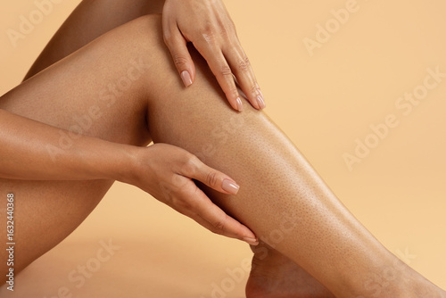 Foto Closeup of woman sitting and gently touching soft smooth skin on her shin