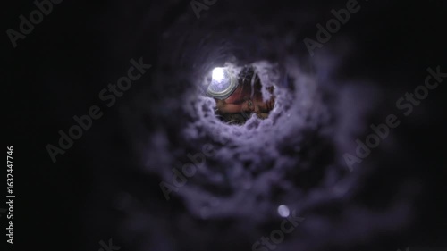 Man inspecting a dryer vent with a flashlight, checking for lint buildup and blockages. The image captures a real-life home maintenance moment, emphasizing fire prevention, appliance safety, and respo