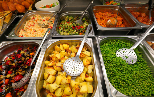 trays of the self service canteen with hot dishes and vegetables like potatoes and green peas