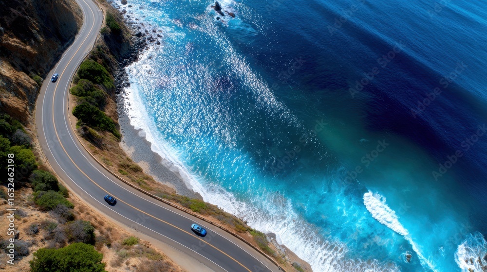 Fototapeta premium Top-down aerial of winding coastal road, cars driving along cliffside, dramatic ocean views, freedom and travel inspiration, perfect for journey stock photo