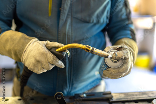 Preparing the welder for welding. Cleaning the welding torch with a protective spray before work