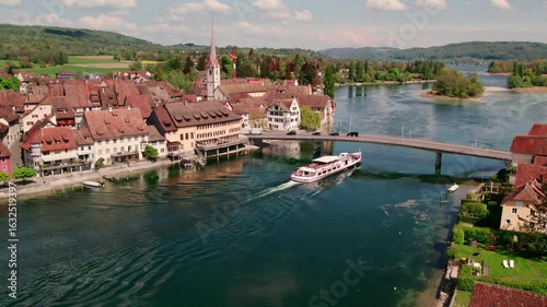 Stein am Rhein Switzerland aerial view of cruise boat passing under bridge slow motion 4k footage Rhine river historic old town Schaffhausen travel destination