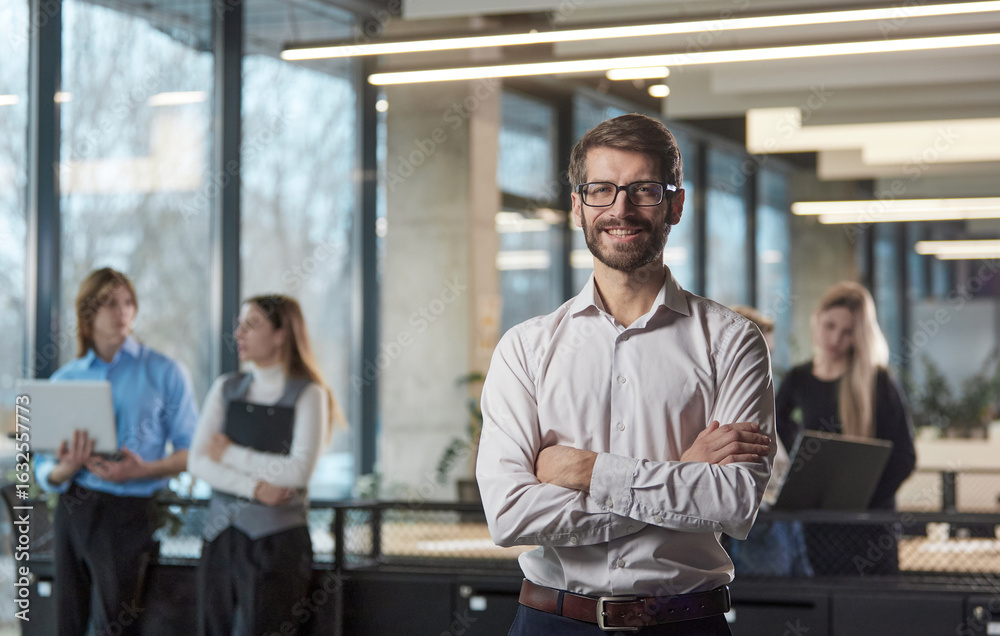 Fototapeta premium A man stands in front of a group of people in a business setting