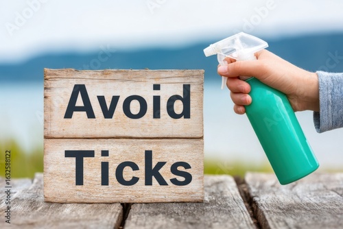 Person spraying tick repellent on wooden sign outdoors