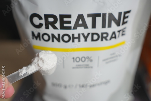 Heaped Scoop of Creatine Powder with Bag in Background