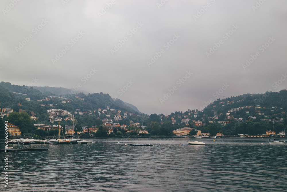 Fototapeta premium lake in the mountains como italy moody autumn foggy look with swans swimming