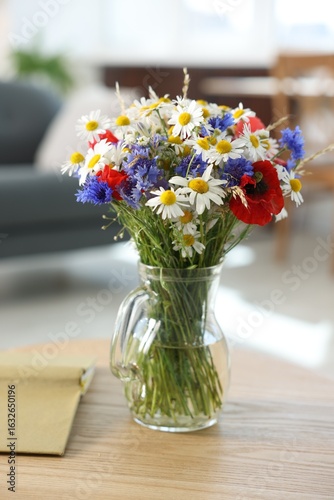 Wallpaper Mural Beautiful wildflowers in vase and book on wooden table at home Torontodigital.ca