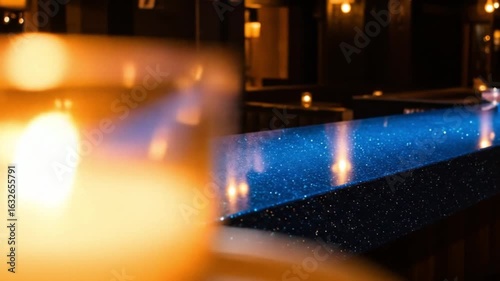 Illuminated bar top with blue glitter and reflections in a dimly lit restaurant