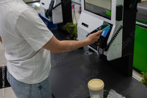 Wallpaper Mural A woman pays using her smartphone at a self-checkout.  Torontodigital.ca