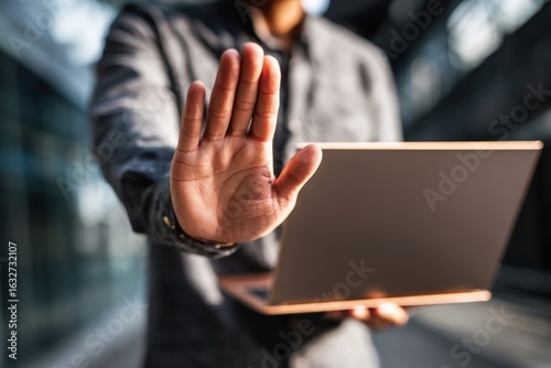 Person holding laptop, hand signals 