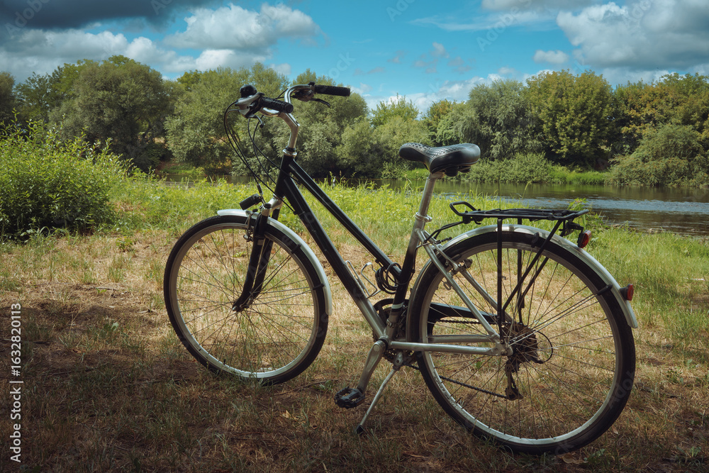 Fototapeta premium City bike on the grass by the river