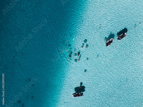 Tourists snorkel with sharks and stingrays in Moorea’s turquoise lagoon.