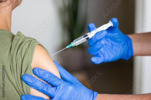 Doctor giving vaccine injection to patient's arm