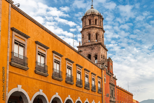 Colonial building with balconies and view of the Temple of San Francisco in Santiago de Queretaro, Mexico