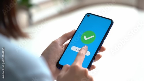 Woman Interacting with Blue Smartphone Displaying Green Checkmark Against a White Background