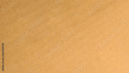Brown color paper shown grain details on  it surface. carton paper or seamless carton background. Yellow paperboard texture.
