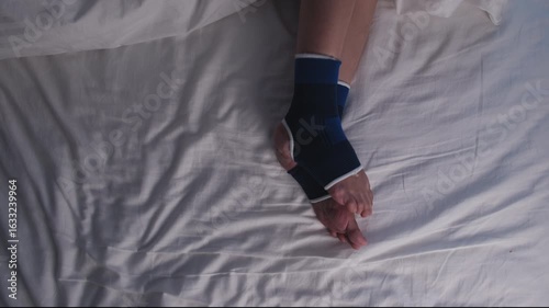 Close-up, woman's irritated legs with ankle support, sleepless from restless leg syndrome, awake at night on bed, with insomnia illness, itching and discomfort problems from healthcare lifestyle.