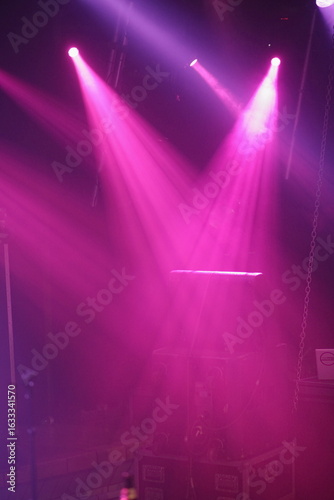 The lights are pink and are shining on the stage