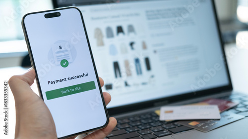 Foto Holding a phone with payment success displayed, and a credit card placed below,