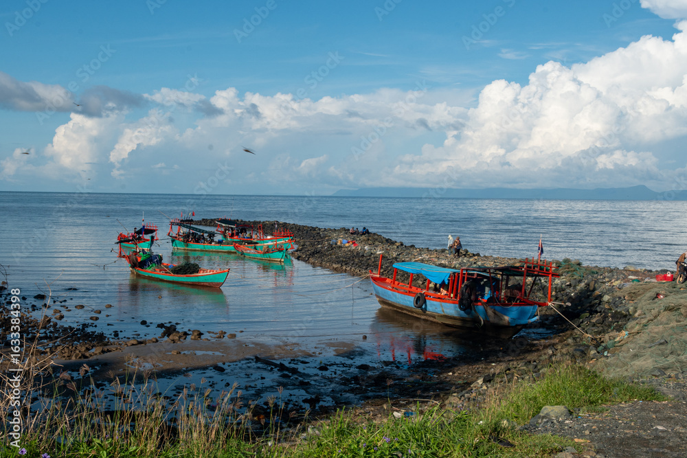 Naklejka premium Traditional crab and seafood market at sunrise in Kep, Cambodia – fishing boats arriving at pier