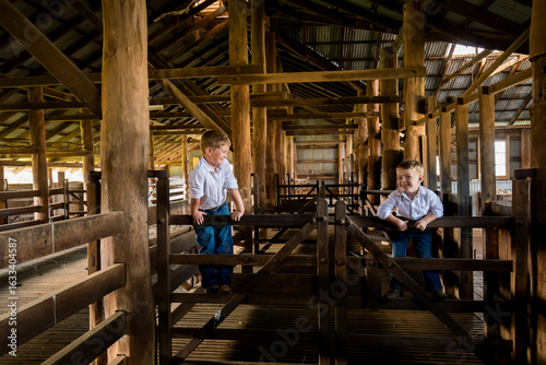 Happy brothers in rustic Australian shearing shed on farm