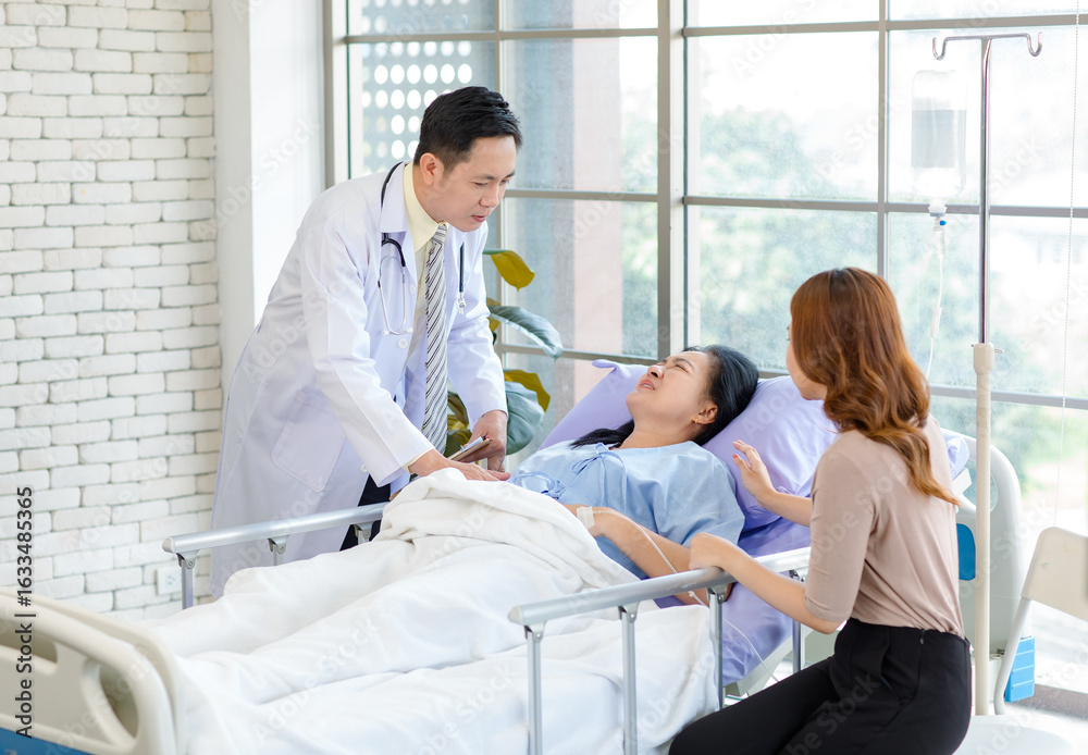 Obraz premium Asian man professional doctor visiting ward, consulting, talking to physician, senior woman patient lying on hospital bed explaining medical treatment with lovely daughter family showing care support.
