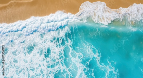 Fototapeta Naklejka Na Ścianę i Meble -  Aerial view of turquoise ocean water washing onto a golden sand beach on a sunny day